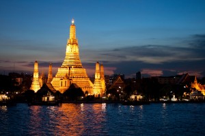 Wat Arun, the Temple of the Dawn, shines across the Chao Phraya River in Bangkok, Thailand.